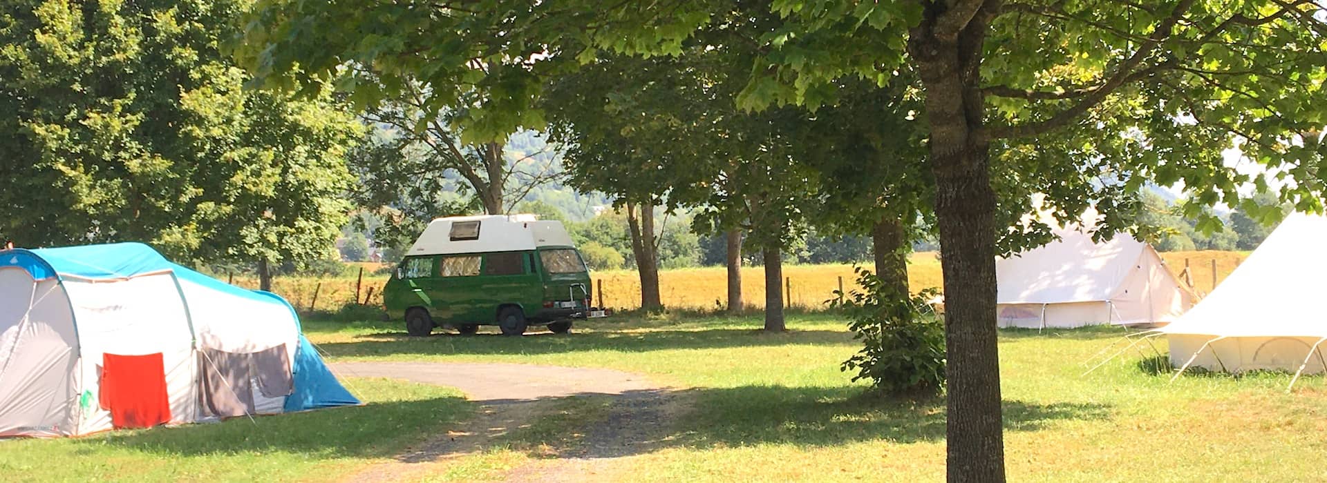 emplacements de camping pour van et tente et une tente glamping à l'ombre sous les arbres